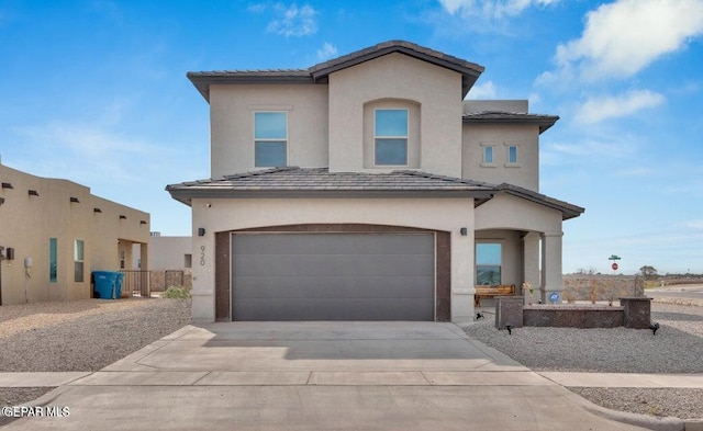 view of front of house with stucco siding, fence, concrete driveway, a garage, and a tiled roof