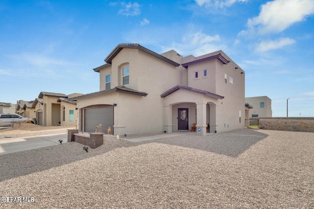 mediterranean / spanish-style house featuring stucco siding, driveway, a garage, and fence