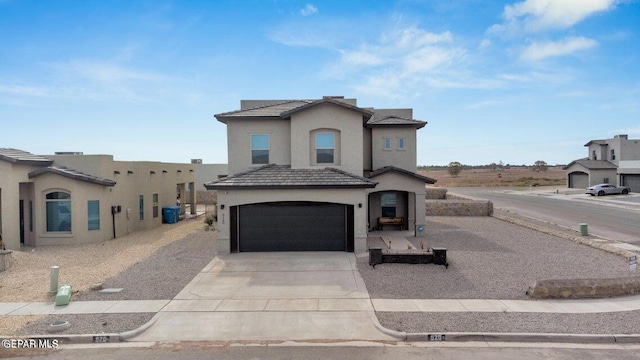 view of front of home with a tile roof, stucco siding, driveway, and an attached garage