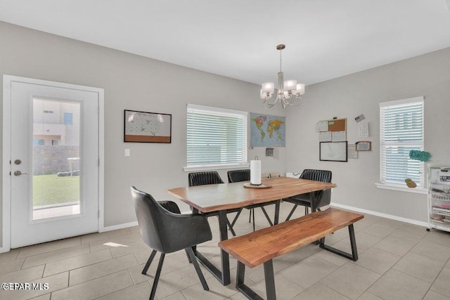 dining room featuring a notable chandelier, baseboards, and light tile patterned floors