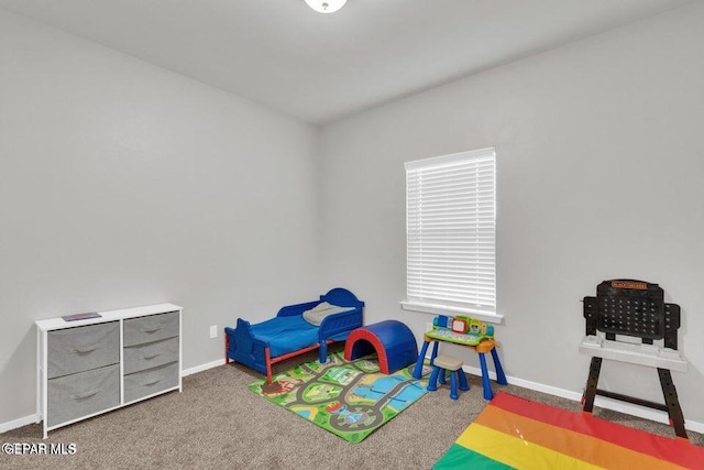 recreation room with baseboards and carpet flooring