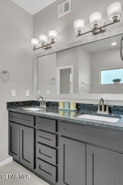 full bath featuring double vanity, visible vents, and a sink