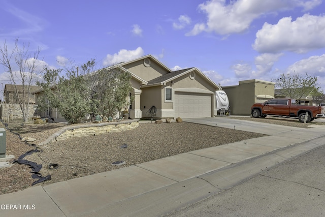 view of front of home with stucco siding, driveway, and an attached garage