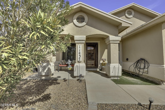 view of exterior entry with stucco siding