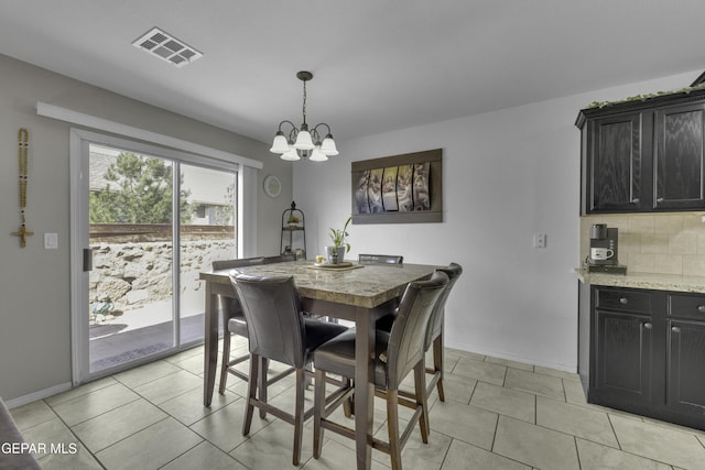 dining space with a notable chandelier, baseboards, visible vents, and light tile patterned floors