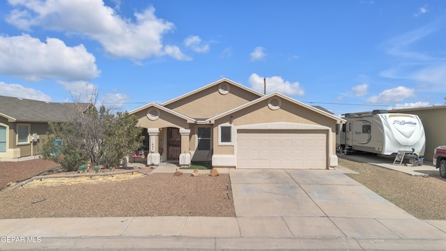 ranch-style home featuring stucco siding, a garage, and driveway