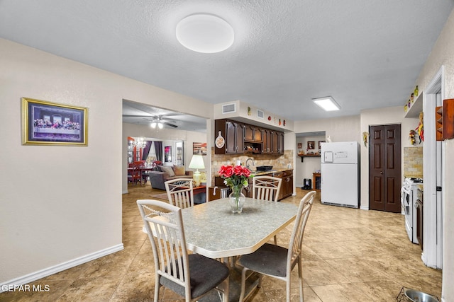 dining area with baseboards, visible vents, a textured ceiling, and ceiling fan