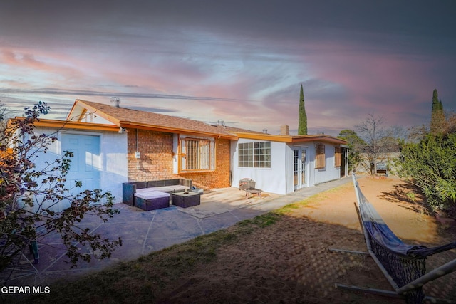 view of front of property featuring a patio area, brick siding, and french doors