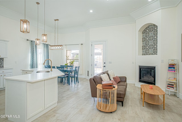 living room with a glass covered fireplace, baseboards, and ornamental molding