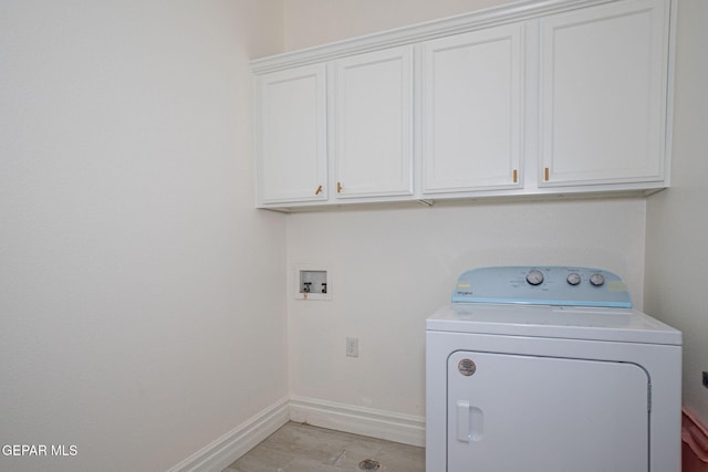 laundry room with baseboards, cabinet space, and washer / dryer