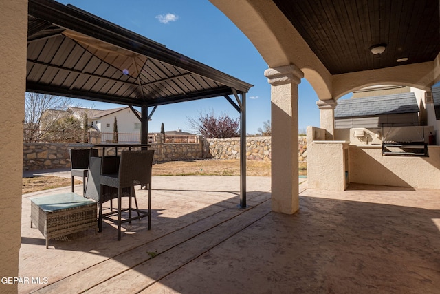 view of patio / terrace with a gazebo, exterior kitchen, and a fenced backyard