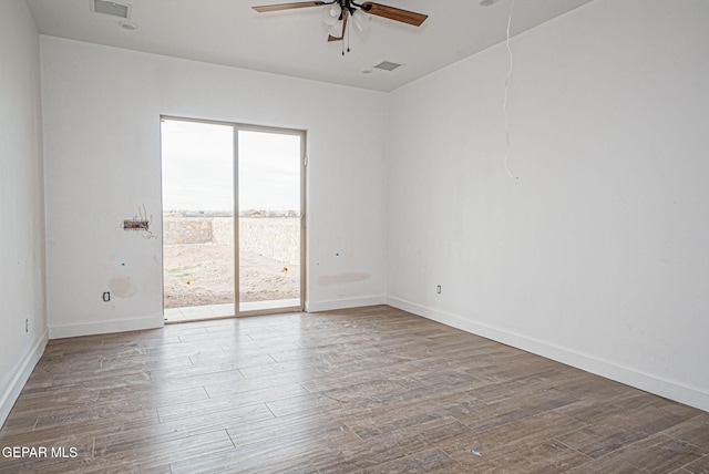 empty room featuring visible vents, baseboards, a ceiling fan, and wood finished floors