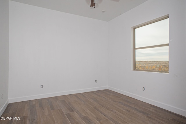 empty room with baseboards, ceiling fan, and wood finished floors