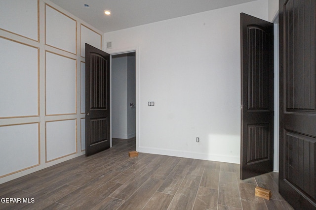 unfurnished bedroom with recessed lighting, wood finished floors, and baseboards