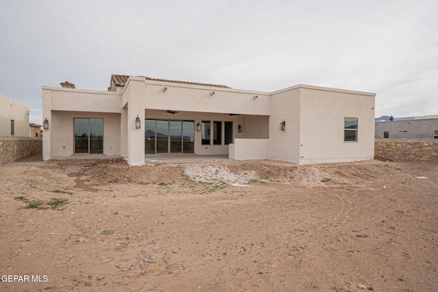 rear view of property featuring ceiling fan, a patio area, fence, and stucco siding