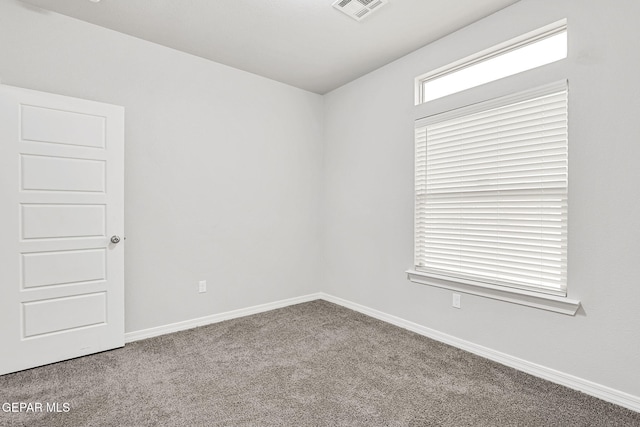 spare room with visible vents, baseboards, and carpet