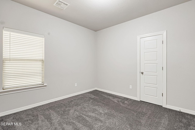 carpeted spare room with baseboards and visible vents