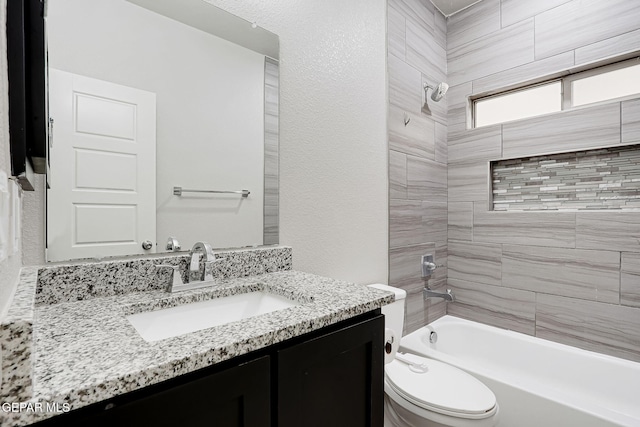 full bathroom featuring vanity, toilet, a textured wall, and shower / bathtub combination