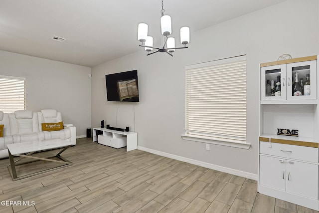 interior space featuring a notable chandelier, visible vents, baseboards, and wood tiled floor