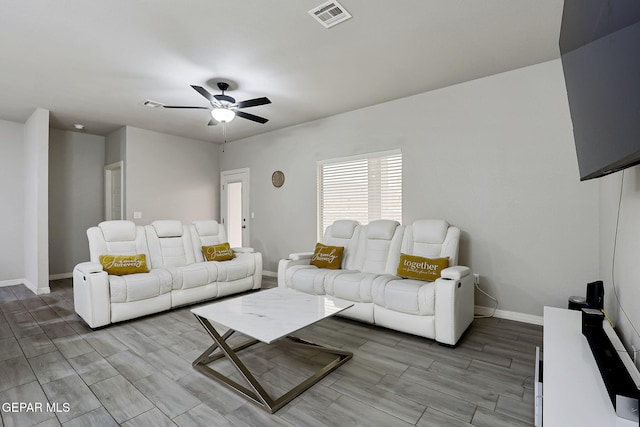 living area featuring wood finish floors, a ceiling fan, visible vents, and baseboards