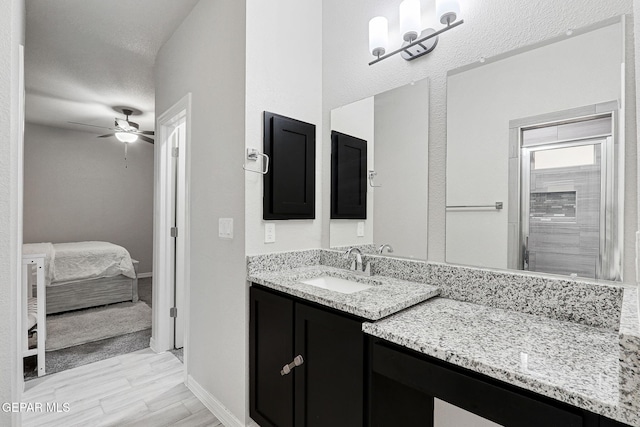 ensuite bathroom with vanity, wood finished floors, baseboards, ceiling fan, and connected bathroom