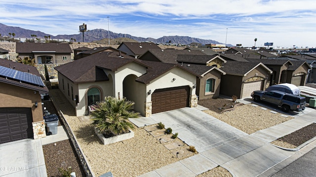 view of front of home featuring an attached garage, a residential view, stucco siding, driveway, and a mountain view