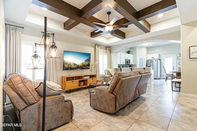 living area with ceiling fan, baseboards, beam ceiling, arched walkways, and coffered ceiling