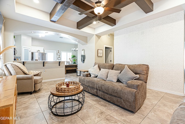 living room featuring arched walkways, beam ceiling, coffered ceiling, and baseboards