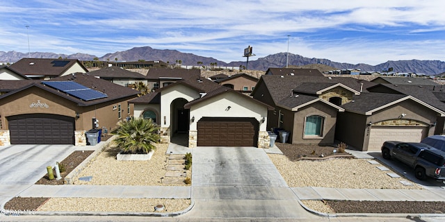 view of front of home featuring driveway, a mountain view, a residential view, and stucco siding