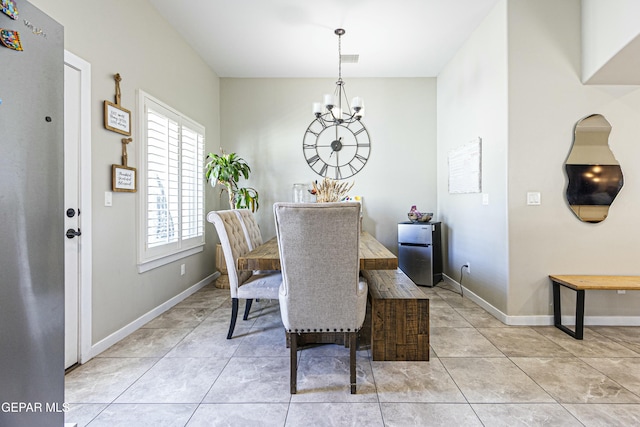 dining space with an inviting chandelier, light tile patterned flooring, visible vents, and baseboards