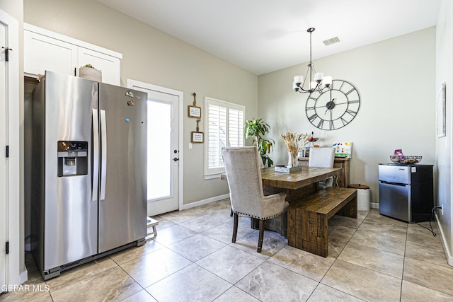 dining area featuring light tile patterned floors, visible vents, baseboards, and a chandelier