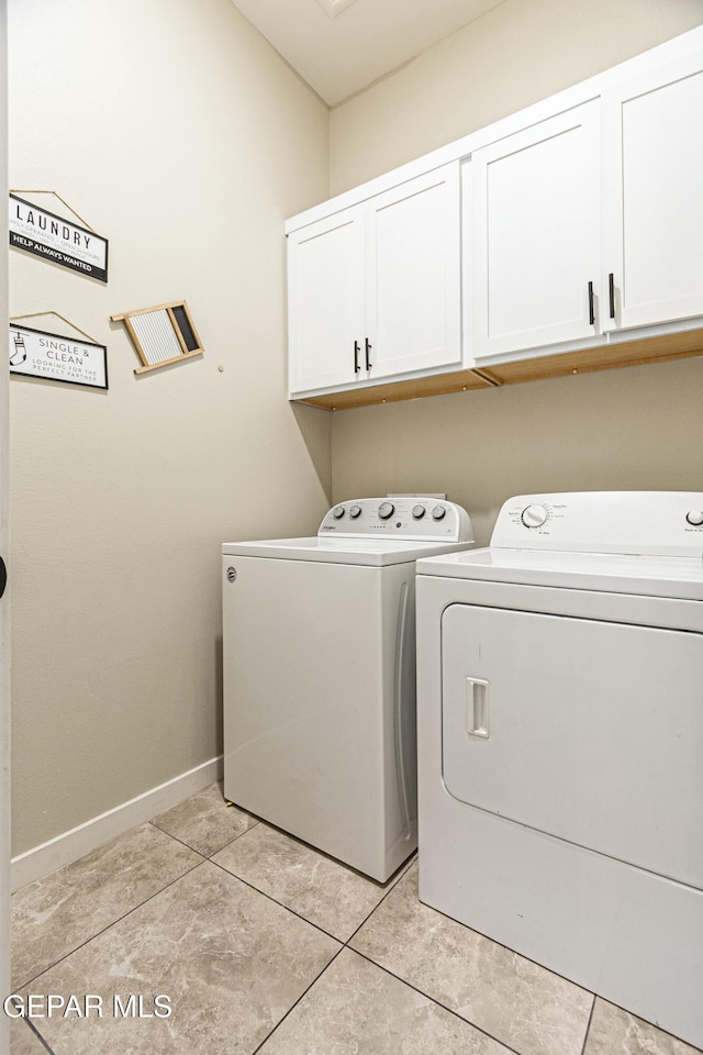 clothes washing area with light tile patterned floors, cabinet space, independent washer and dryer, and baseboards