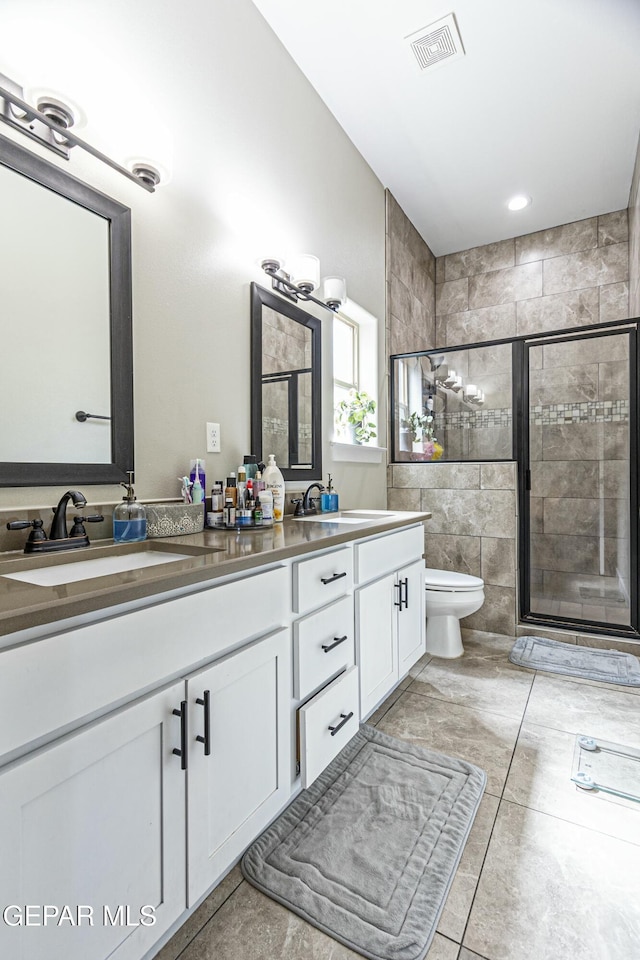 full bath with a sink, visible vents, a stall shower, and double vanity