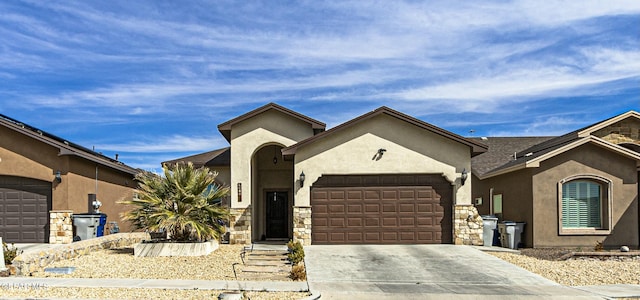 view of front of home with stone siding, stucco siding, an attached garage, and concrete driveway