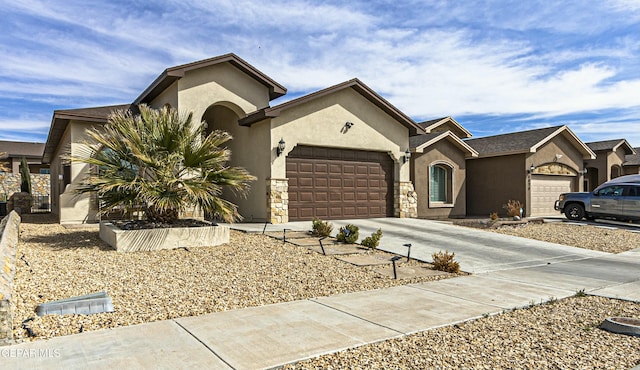 view of front facade featuring stone siding, stucco siding, concrete driveway, and a garage