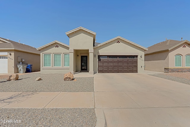 view of front of home with concrete driveway, an attached garage, and stucco siding