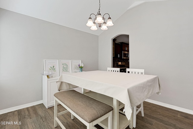 dining room with vaulted ceiling, wood finished floors, and baseboards