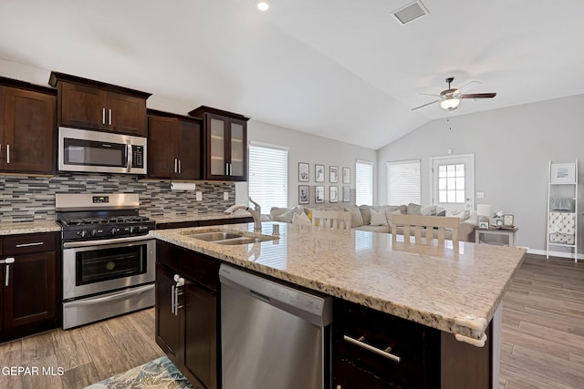 kitchen featuring visible vents, a sink, open floor plan, appliances with stainless steel finishes, and lofted ceiling