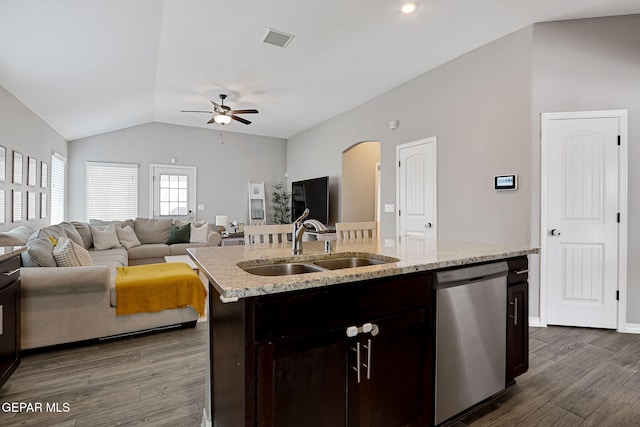 kitchen with dark wood-style floors, visible vents, arched walkways, a sink, and stainless steel dishwasher