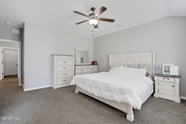 bedroom featuring visible vents, baseboards, dark carpet, and vaulted ceiling