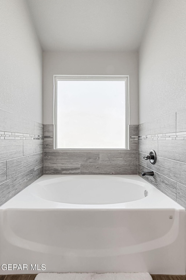 bathroom featuring a garden tub and plenty of natural light