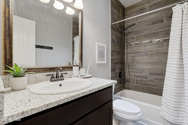 bathroom featuring toilet, shower / bath combo with shower curtain, and vanity