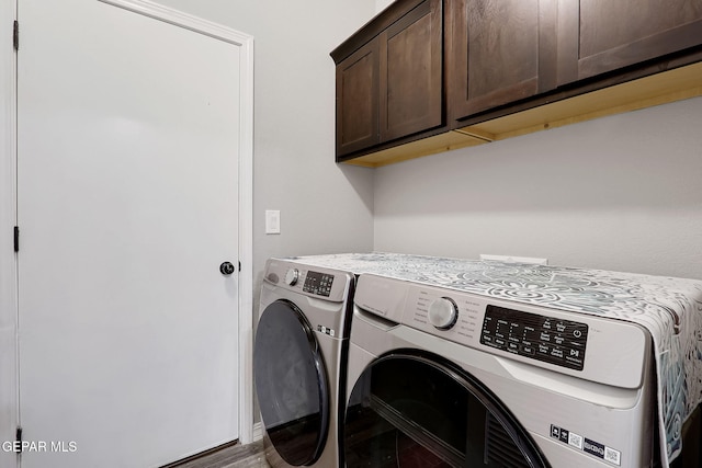 clothes washing area with cabinet space and independent washer and dryer