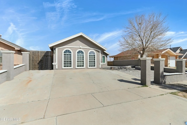 back of property featuring stucco siding and fence