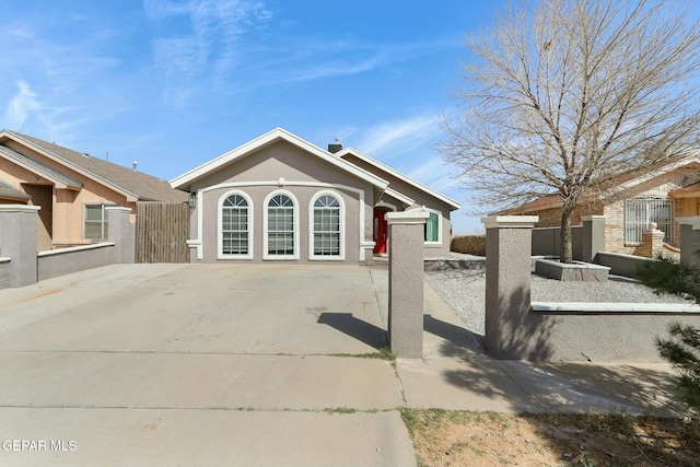 view of front of home featuring stucco siding and fence