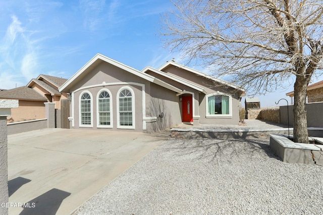 ranch-style home with stucco siding and fence