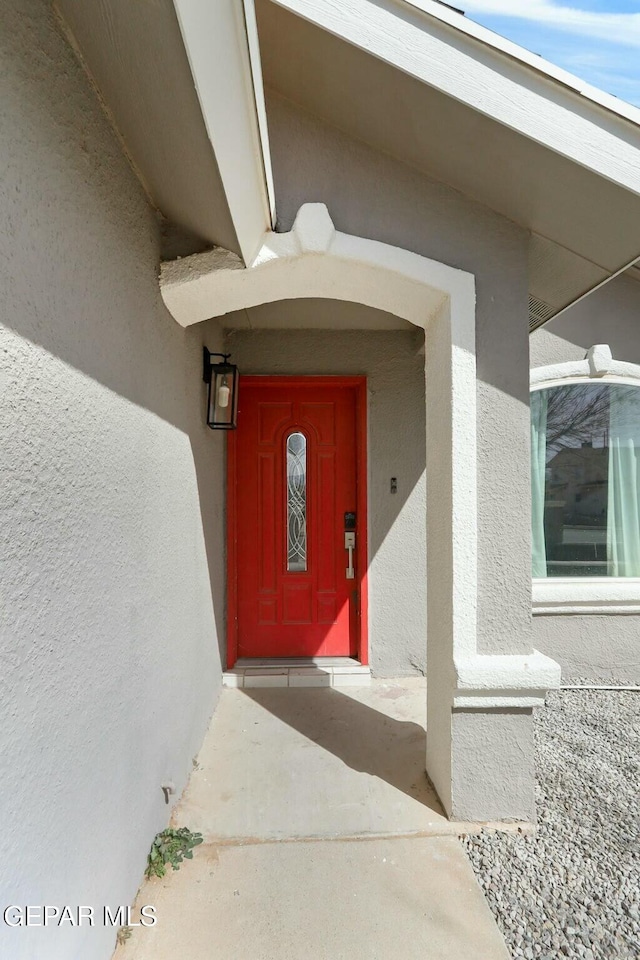 doorway to property featuring stucco siding