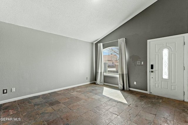 foyer entrance with stone finish floor, baseboards, and vaulted ceiling