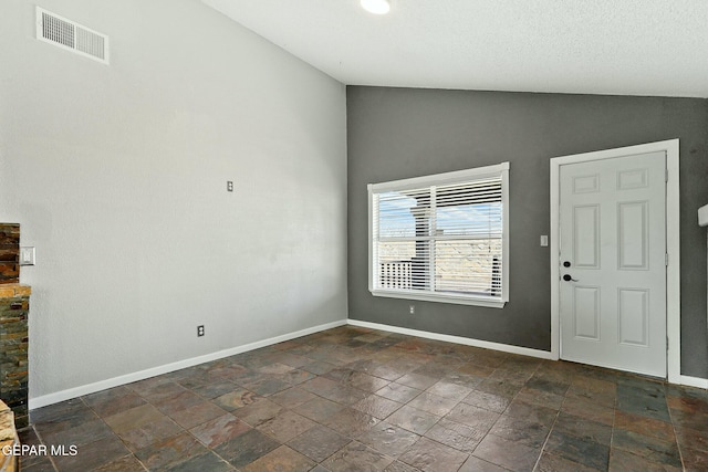 foyer with visible vents, lofted ceiling, and baseboards