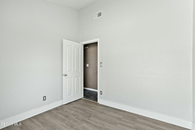 empty room featuring visible vents, baseboards, and wood finished floors